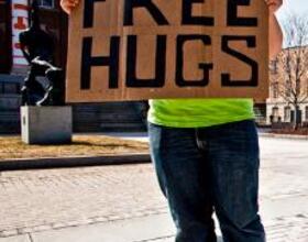 With arms wide open : Free hugs guy spreads cheer but keeps identity a secret